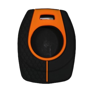 May include: A black and orange silicone key fob cover featuring a central circular cutout, a rectangular attachment slot at the top, and a textured honeycomb pattern on the left side, with a vertical orange line extending from the center circle.
