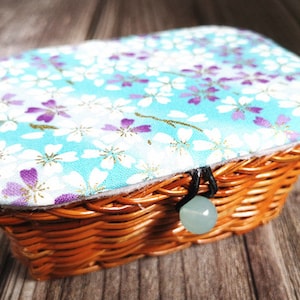 Sewing box rattan knit basket with cloth art lid contains sewing accessories