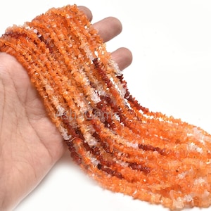 Puede incluir: Una hebra de cuentas de chip de cornalina naranja, roja y blanca. Las cuentas son de forma irregular y tienen una textura natural y rugosa.