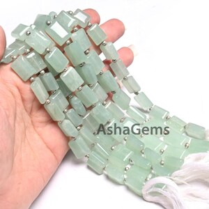 Puede incluir: Una hebra de cuentas de piedras preciosas verde claro con separadores de plata. Las cuentas son rectangulares y tienen un acabado liso y pulido. La hebra mide aproximadamente 45 cm de largo.