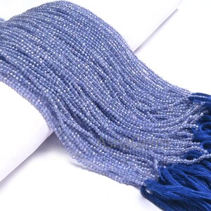 Puede incluir: Una hebra de cuentas de piedras preciosas de color azul claro con un borla azul. Las cuentas son peque&ntilde;as y redondas, y la borla est&aacute; hecha de un material suave y sedoso.