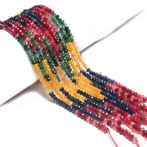 May include: A strand of faceted gemstone beads in four colors: red, green, blue, and yellow. The beads are strung on a thin cord and are ready to be used for jewelry making.