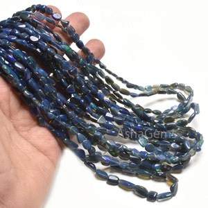 May include: A strand of blue, green, and black opal gemstone beads. The beads are oval shaped and have a smooth, polished finish.