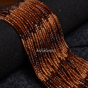 May include: A strand of brown and orange gemstone beads. The beads are faceted and have a shiny finish. The beads are strung on a clear thread and are ready to be used for jewellery making.