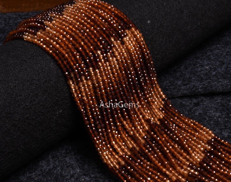 May include: A strand of brown and orange gemstone beads. The beads are faceted and have a shiny finish. The beads are strung on a clear thread and are ready to be used for jewellery making.