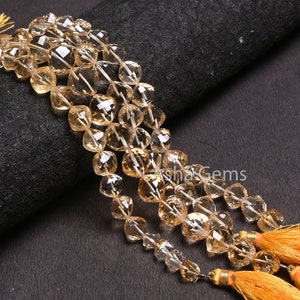 May include: A strand of faceted citrine beads with a golden yellow colour. The beads are strung on a wire and have a tassel at the end. The beads are approximately 8mm in size.