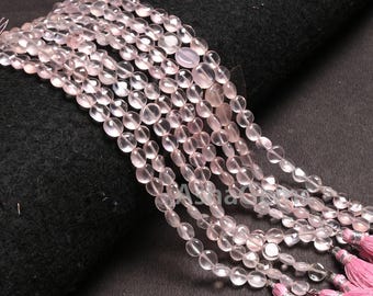 May include: Strands of rose quartz beads in a soft pink colour. The oval-shaped beads are strung together, with pink tassels at the end. The beads are displayed against a dark background.