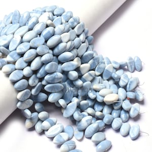 May include: A strand of light blue and white oval-shaped gemstone beads. The beads are smooth and polished, and they have a natural, organic look.