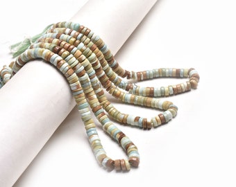 May include: A strand of light green, brown, and white round beads. The beads are made of natural stone and are strung on a white cord.