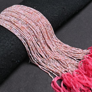 May include: A strand of pink opal beads, approximately 2mm in size, with a pink tassel at the end. The beads are strung on a thin thread and are ready to be used for jewelry making.