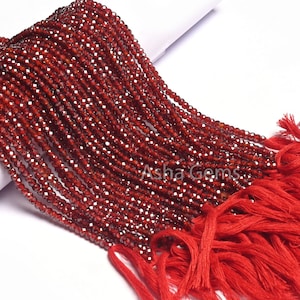 Puede incluir: Una hebra de cuentas de granate rojo con acabado facetado. Las cuentas están enhebradas en un hilo y tienen un borla en el extremo. Las cuentas tienen aproximadamente 4 mm de diámetro.