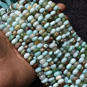 May include: A strand of light blue, green, and brown gemstone beads. The beads are faceted and have a smooth, polished finish. The beads are strung on a clear thread and are ready to be used for jewellery making.