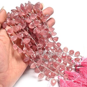 Peut inclure: Un brin de perles de quartz rose en forme de feuille. Les perles sont enfilées sur un fil d'argent et ont une apparence naturelle et translucide.