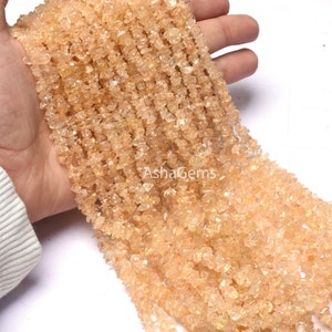 May include: A strand of small, irregular, light orange gemstone chips. The chips are translucent and have a slight shimmer. The strand is approximately 18 inches long.