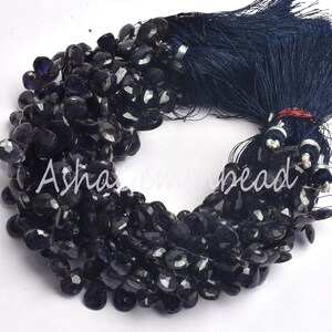 Peut inclure: Un brin de perles de pierres précieuses facettées bleu foncé, avec un pompon bleu foncé. Les perles sont de forme irrégulière et ont un aspect brut et naturel.