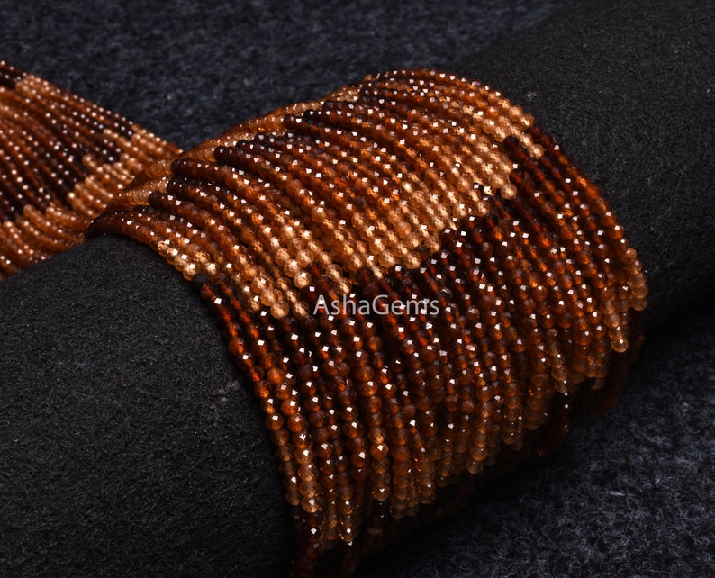 May include: A strand of brown and orange gemstone beads. The beads are faceted and have a shiny finish. The beads are strung on a clear thread and are ready to be used for jewellery making.