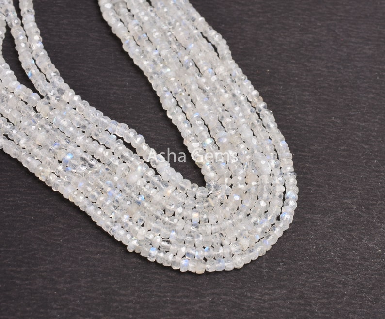 May include: A strand of white moonstone beads, approximately 4mm in size, with a slight iridescent shimmer. The beads are strung on a clear thread and are arranged in a loose, flowing pattern.