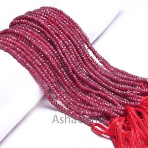 Puede incluir: Una hebra de cuentas de piedras preciosas de color rojo rubí con superficies facetadas. Las cuentas están enhebradas en un hilo fino y tienen un borla al final.