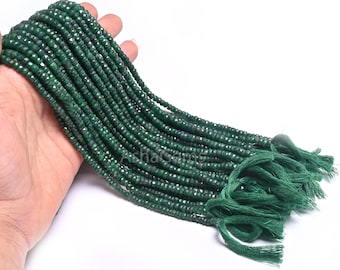 May include: A strand of dark green gemstone beads, likely emerald, with a tassel at the end. The beads are faceted and have a smooth, polished finish.