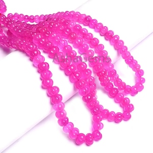 May include: Strands of bright pink beads with a floral design. The beads are strung together, creating a flowing, textured appearance. The beads are a vibrant shade of pink, and the floral design adds a delicate touch to the overall aesthetic.