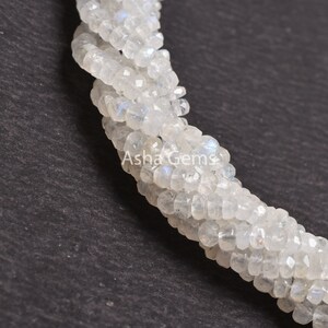 May include: A strand of white moonstone beads, each bead is faceted and has a slightly iridescent sheen. The beads are strung together in a continuous strand, and the strand is twisted into a spiral shape. The beads are approximately 4mm in diameter.