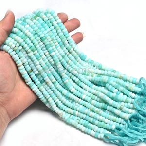 以下が含まれることがあります： 約4mmの薄い青色のオパールビーズのストランド。ビーズは丸く、滑らかで磨かれた仕上げになっています。ストランドは約40cmの長さで、透明な伸縮性のあるコードに糸で通されています。