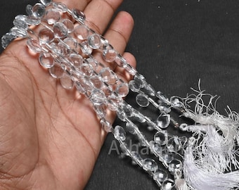 May include: A strand of clear quartz crystal beads, faceted and round, with a white tassel at the end.