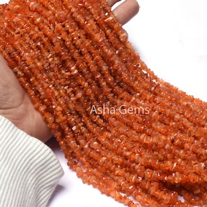 Peut inclure: Un brin de perles en forme de chips de cornaline orange. Les perles sont de forme irrégulière et ont une finition naturelle et polie.