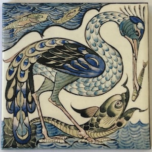 May include: A blue and green bird with a long neck and a long beak is depicted on a white tile. The bird is standing on a green snake and is holding a fish in its beak. The background is a blue and white wave pattern.