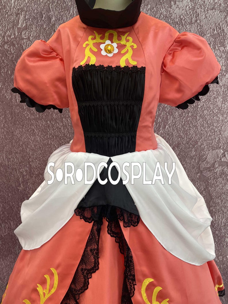 May include: A coral-colored cosplay dress with black and white accents. The bodice features a black panel with lace trim and a decorative yellow design. The dress has puffed sleeves and a full skirt. The text "SORODCOSPLAY" is visible.