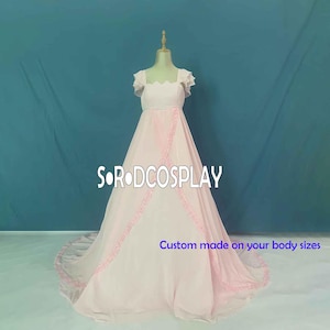 Könnte beinhalten: Ein rosa Ballkleid mit einem herzförmigen Ausschnitt und kurzen, gekräuselten Ärmeln. Das Kleid hat einen mehrlagigen Rock mit Spitzenbesatz und einen Schleier. Das Kleid wird auf einer Schaufensterpuppe vor einem blauen Hintergrund präsentiert. Maßgeschneidert nach Ihren Körpermaßen.