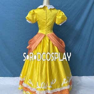 May include: A yellow cosplay dress with a white collar and puff sleeves. The dress features orange accents at the waist and hem, with white and orange lace trim. The text "SORODCOSPLAY" is visible on the dress.