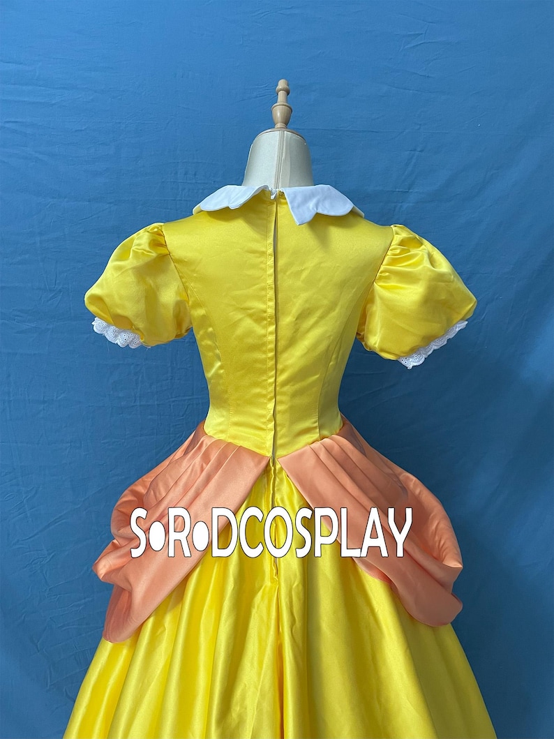 May include: A yellow satin dress with a white collar and peach-colored accents. The dress features short, puffed sleeves with white lace trim. The text "SORODCOSPLAY" is visible on the dress.