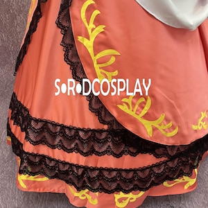 May include: A close-up of a peach-colored garment with black lace trim and yellow decorative accents. The text "S OR DCOSPLAY" is visible on the fabric. The garment appears to be part of a costume or dress.