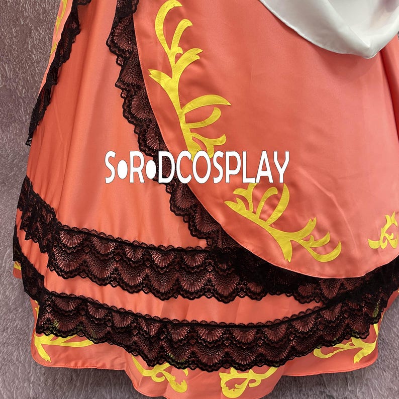 May include: A close-up of a peach-colored garment with black lace trim and yellow decorative accents. The text "S OR DCOSPLAY" is visible on the fabric. The garment appears to be part of a costume or dress.