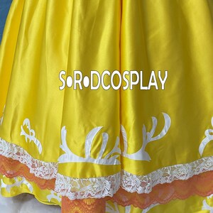 May include: A close-up of a yellow dress with white decorative accents and orange lace trim. The text "SORODCOSPLAY" is printed in white across the dress. The dress has a satin-like sheen.