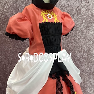 May include: A coral-colored costume dress with black and white accents. The bodice features a black, ruched panel and a high, black collar. Gold and white floral designs adorn the bodice. The skirt has black lace trim and a white drape.