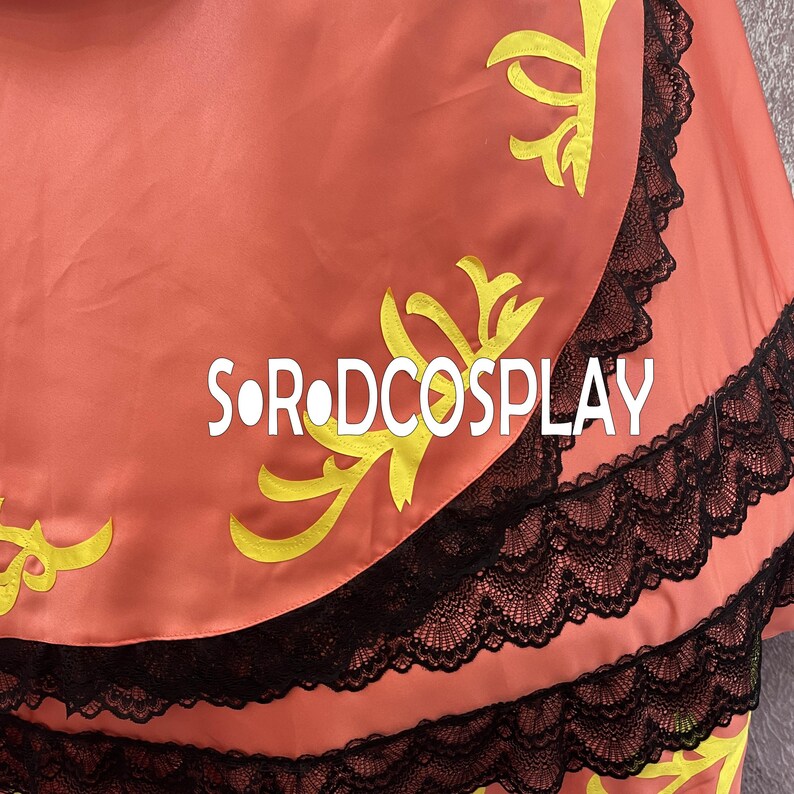 May include: A coral-colored fabric with yellow floral designs and black lace trim. The text "SOR DCOSPLAY" is printed in white across the fabric. The fabric appears to be part of a costume or garment.