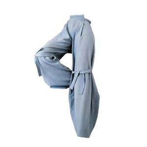 Puede incluir: Pantalones anchos de color azul claro con cinturón a juego. Los pantalones tienen cintura alta y están hechos de una tela suave y fluida. El diseño presenta pliegues en la cintura y un ajuste relajado, adecuado para diversas ocasiones.