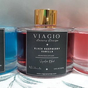 May include: Three glass bottles of reed diffuser with gold caps and black labels. The labels have the text "VIAGIO Luxury Design" and the scent names "Fresh Linen", "Black Raspberry Vanilla", and "Jasmine & Rose".