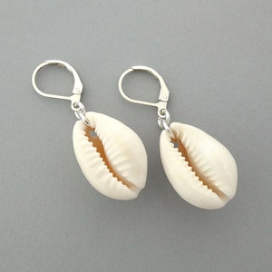 May include: A pair of silver earrings with white cowrie shell charms.