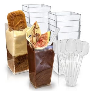 May include: Clear plastic dessert cups filled with layered desserts, including chocolate mousse with a fig slice and a cake with cream. A stack of empty square cups and a bundle of clear plastic spoons are also visible.