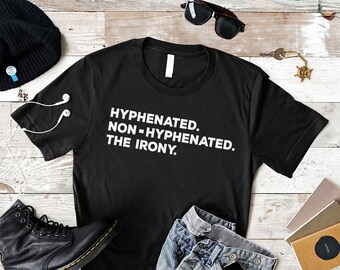 May include: Black t-shirt with white text that reads "HYPHENATED. NON-HYPHENATED. THE IRONY."