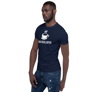 Pu&ograve; includere: Una t-shirt blu navy con un designo di una tazza di caff&egrave; bianca e vapore. Il testo "JAVA DEVELOPER" &egrave; stampato sotto la tazza.