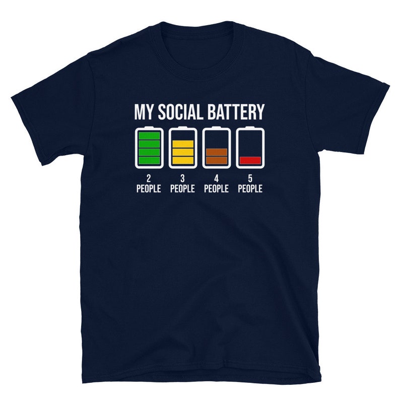 May include: A navy blue t-shirt with the text "My Social Battery" and a graphic of four battery icons. The battery icons are green, yellow, brown, and red, representing different levels of charge. The text "2 People", "3 People", "4 People", and "5 People" is below the battery icons.