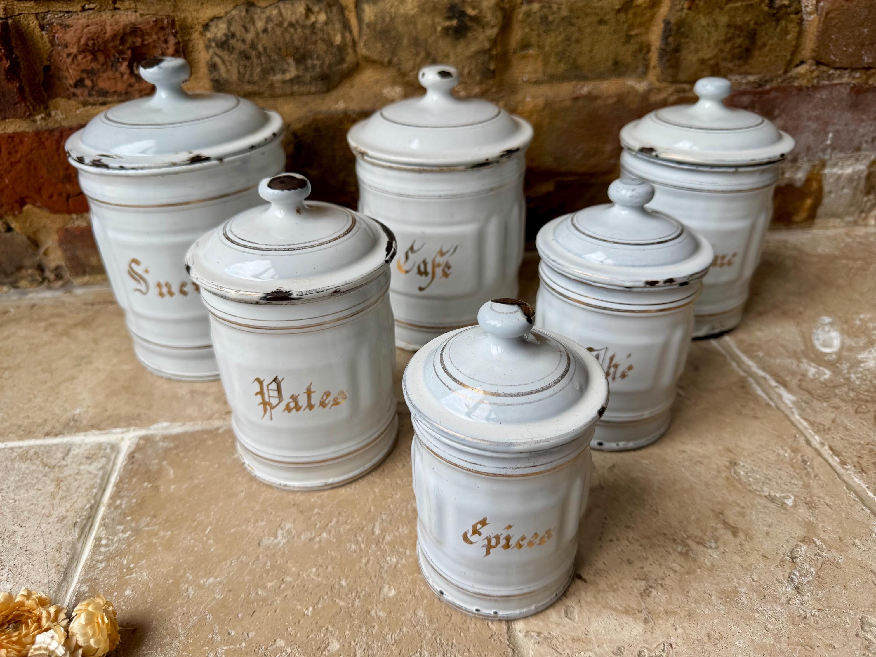 Antieke Franse set van zes wit geëmailleerde keukenvoorraadpotten of -bussen | Witte en goudkleurige Franse potten | Huisstijl Franse brocante
