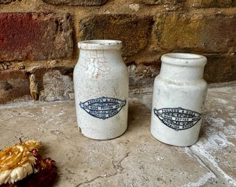 May include: Two vintage white ceramic jars with blue and black labels that read "Paulton & Noel Home-Made Potted Meats Belgravian Brand".