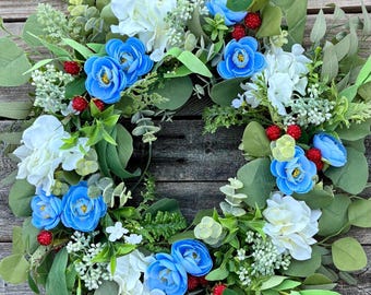 Corona patriótica del 4 de julio con flores de colores vibrantes: rojo, blanco y azul. Decoración para el Día de la Independencia. Corona del 4 de julio.