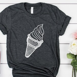 Puede incluir: Una camiseta gris oscuro con un gr&aacute;fico blanco de un cono de helado.