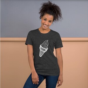 Puede incluir: Una camiseta gris oscuro jaspeada con un contorno blanco de un cono de helado.